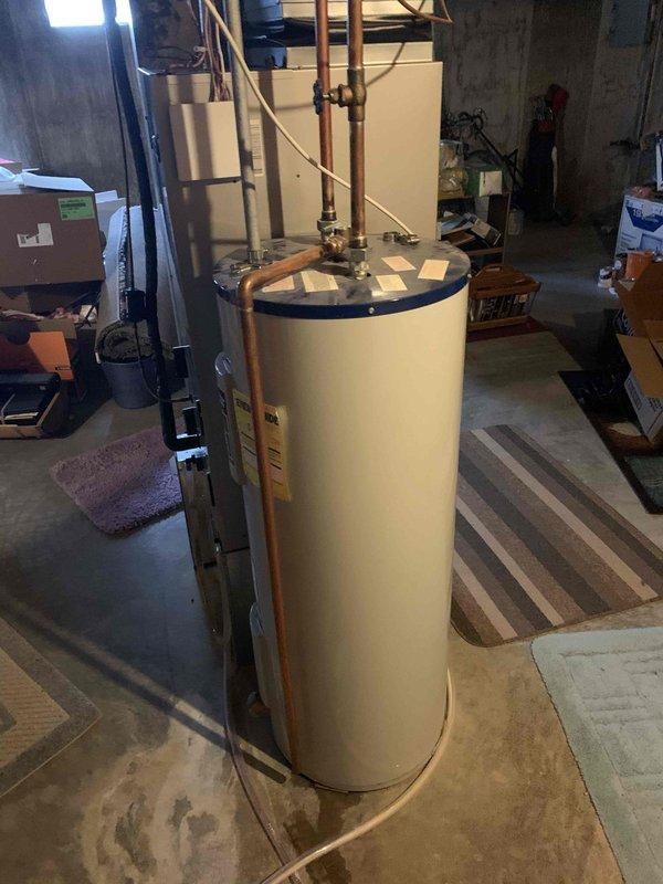 Replaced a 35-year-old 40-gallon electric water heater that was leaking from the bottom with a new 40-gallon electric tall unit in the basement. Installed a 3/4-inch pressure reducing valve as part of the installation and connected all necessary copper supply lines and pressure relief valve plumbing. The unit was set up and delivered for installation without obtaining a water heater permit per customer specifications.