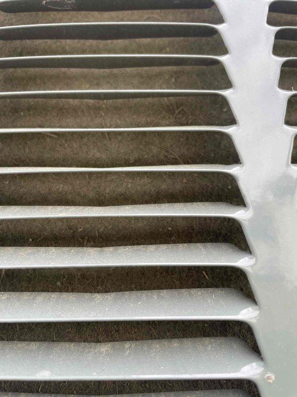 Completed comprehensive cooling system tune-up on residential AC unit located at side of home. Performed standard maintenance protocol including inspection of evaporator coil assembly, which showed moderate dust accumulation between aluminum fins, and return air grille, which exhibited significant dust and debris buildup on internal surfaces and slat edges. Documented system condition with photographs for service records.