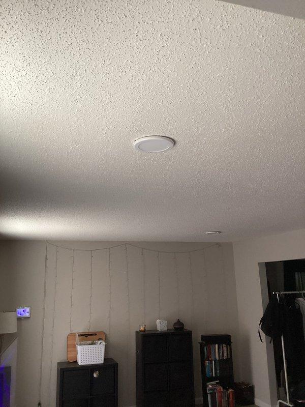 Conducted on-site electrical assessment for installation of new recessed lighting fixture in living room with textured popcorn ceiling and vertical wall paneling. Evaluated ceiling structure, existing electrical infrastructure, and optimal fixture placement to provide comprehensive estimate for recessed light installation.