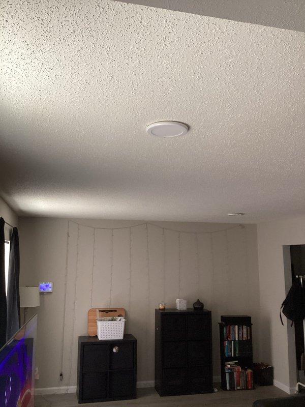 Conducted on-site electrical assessment for installation of new recessed lighting fixture in living room with textured popcorn ceiling and vertical wall paneling. Evaluated ceiling structure, existing electrical infrastructure, and optimal fixture placement to provide comprehensive estimate for recessed light installation.