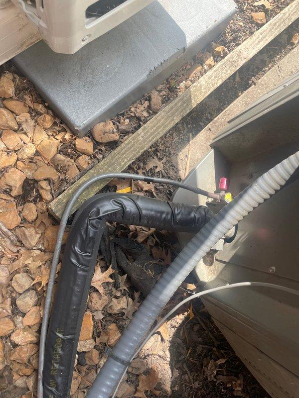 Replaced deteriorated exterior insulation on HVAC line set at outdoor unit installation. Removed old insulation pad from ground-level utility area and installed new foam insulation to protect refrigerant lines from environmental exposure. System tested and confirmed operational for heating and cooling functions upon completion.