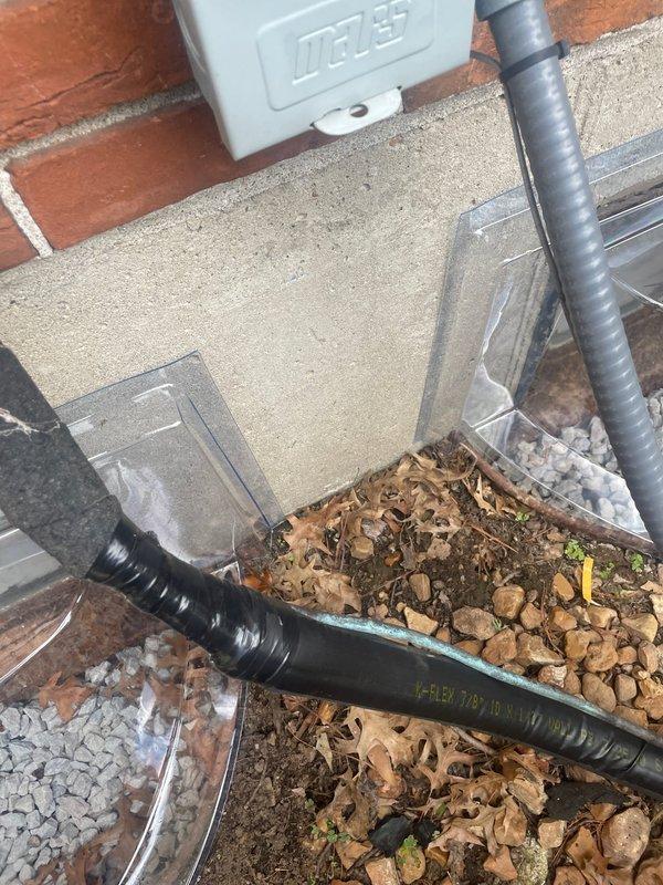 Replaced deteriorated exterior insulation on HVAC line set at outdoor unit installation. Removed old insulation pad from ground-level utility area and installed new foam insulation to protect refrigerant lines from environmental exposure. System tested and confirmed operational for heating and cooling functions upon completion.