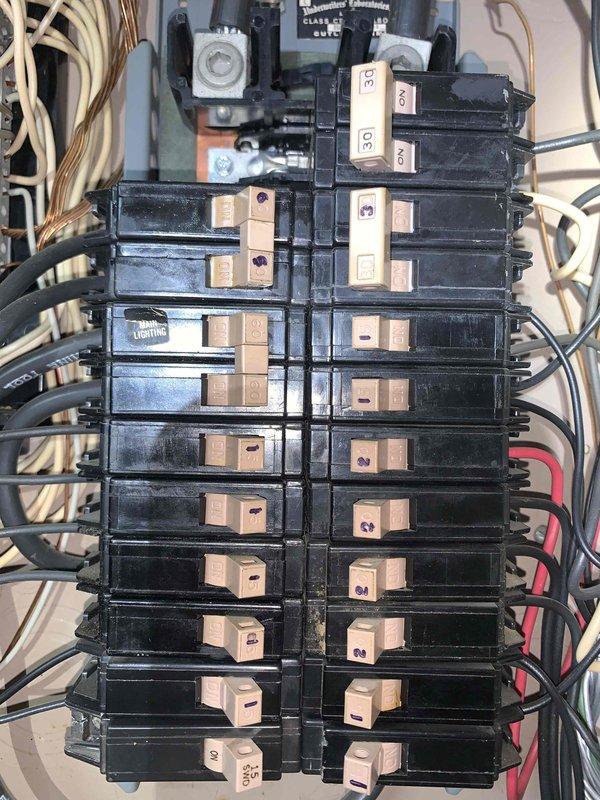 Performed complimentary electrical inspection of residential service panel located in unfinished basement area. Conducted visual assessment of main breaker panel configuration, which contained multiple circuit breakers rated at various amperages (30A, 50A) arranged in dual columns with main disconnect assembly at top. Evaluated condition of panel wiring including bundled conductors, verified proper wire routing and organization along panel edges, and documented overall system configuration with photographic evidence for homeowner records.