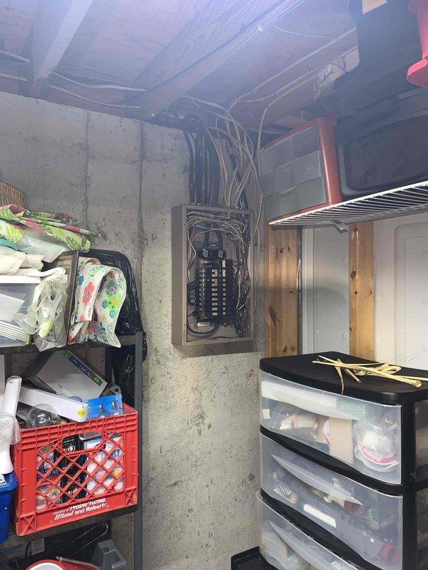 Performed complimentary electrical inspection of residential service panel located in unfinished basement area. Conducted visual assessment of main breaker panel configuration, which contained multiple circuit breakers rated at various amperages (30A, 50A) arranged in dual columns with main disconnect assembly at top. Evaluated condition of panel wiring including bundled conductors, verified proper wire routing and organization along panel edges, and documented overall system configuration with photographic evidence for homeowner records.