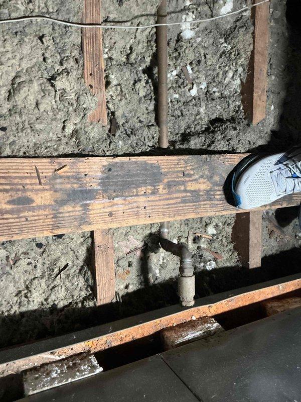 Performed diagnostic evaluation on residential air conditioning system over 10 years old located at side of home. Accessed crawl space and inspected mechanical components including refrigerant lines, shut-off valves, and ductwork. Assessed condition of piping system, connections, and equipment housing in confined utility area beneath structure.