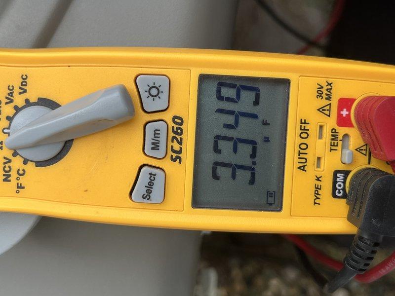 Completed comprehensive cooling tune-up on single outdoor ground-mounted AC unit of unknown age. Performed standard diagnostic testing using digital multimeter, recording temperature readings of 67.7°F and electrical measurements of 0.03 AC volts to verify proper system operation and electrical integrity.