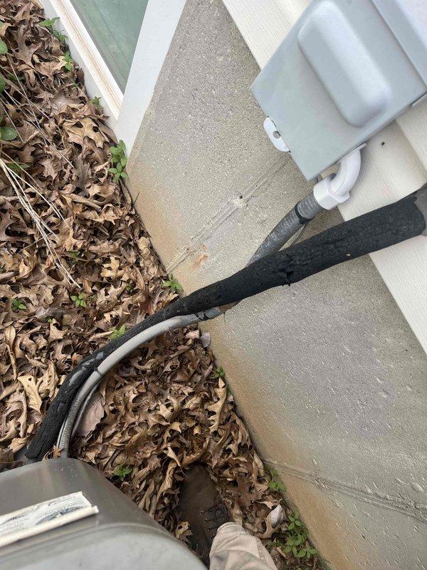 Responded to service call for 11-year-old outdoor A/C unit with damaged foam insulation on refrigerant line set. Upon inspection, found that the foam insulation covering the suction line had split open and deteriorated due to winter weather exposure. Replaced damaged foam insulation on exposed refrigerant piping to restore proper insulation and prevent efficiency loss and condensation issues.