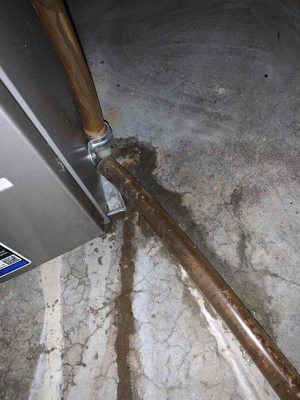 Responded to service call for recurring AC condensate drain hose disconnection causing water leakage near furnace and indoor unit, with water damage occurring on carpeting. Upon inspection of 11-year-old Lennox system, found condensate drain line had been temporarily repaired previously but connection remained inadequate and prone to separation. Evaluated drain routing from evaporator coil and identified improper fitting connection at transition point near air handler. Disconnected existing temporary repair, cleaned pipe connections, and installed proper PVC coupling with primer and cement to create permanent sealed connection. Verified drain line slope for proper gravity drainage and secured all connections. Tested condensate drainage system by pouring water through drain pan to confirm positive flow without leaks at repair point. Inspected surrounding area for water damage and advised on monitoring carpet for complete drying. System operational with secure drain connections establish