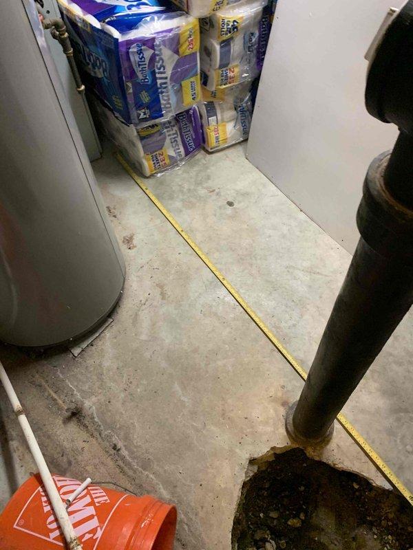 Responded to call back for sewer line issues and performed thorough inspection of the affected area. Upon arrival, identified significant water damage and staining on concrete floor surrounding the sewer line connection point, indicating previous leakage or drainage problems. Documented existing conditions showing deterioration around pipe base and floor collar, with visible moisture infiltration and efflorescence present on concrete surfaces. Measured affected area and photographed evidence of corroded pipe base and accumulated rust deposits at floor penetration. Verified proper installation of replacement PVC piping and confirmed all connections were secure and functioning correctly, resolving the original service concerns.