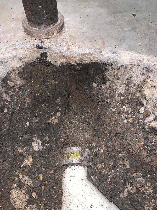 Responded to call back for sewer line issues and performed thorough inspection of the affected area. Upon arrival, identified significant water damage and staining on concrete floor surrounding the sewer line connection point, indicating previous leakage or drainage problems. Documented existing conditions showing deterioration around pipe base and floor collar, with visible moisture infiltration and efflorescence present on concrete surfaces. Measured affected area and photographed evidence of corroded pipe base and accumulated rust deposits at floor penetration. Verified proper installation of replacement PVC piping and confirmed all connections were secure and functioning correctly, resolving the original service concerns.