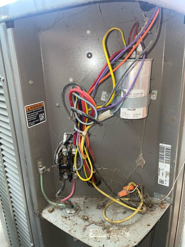 Responded to no-cool call on Lennox outdoor condensing unit in backyard. Customer reported unit not activating when called by thermostat. Upon inspection, found unit with loose cover and accessed electrical panel. Verified capacitor condition and checked contactor operation. Inspected all wire connections including control wiring (yellow, red, orange, purple, white) and power supply. Tested unit operation and confirmed proper startup sequence. System now responding correctly to thermostat calls.