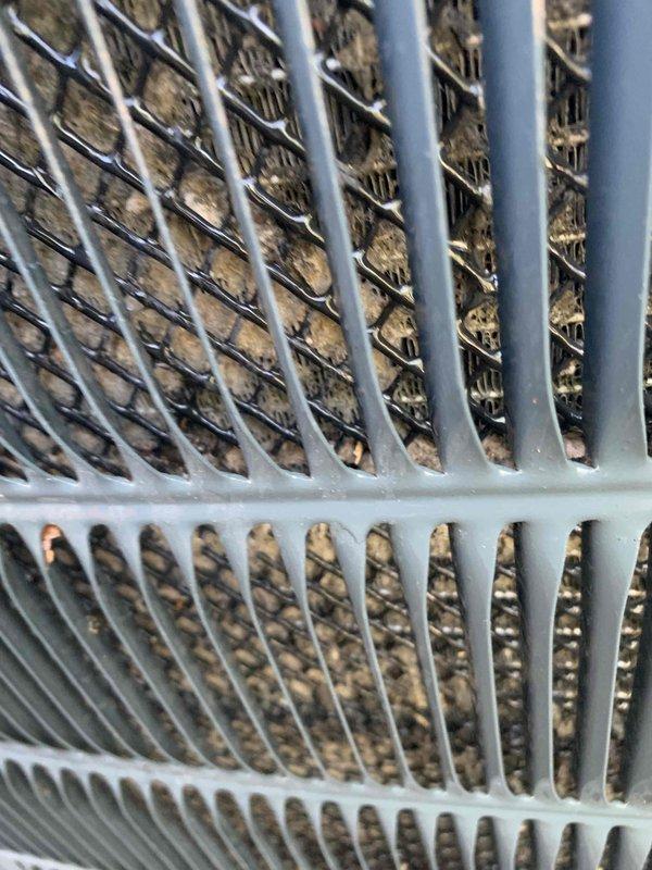 Completed comprehensive cooling season tune-up on single AC unit with ground-level condenser and attic air handler. Condenser coils showed significant accumulation of dirt, dust, and organic debris requiring thorough cleaning to restore proper airflow and heat transfer efficiency. Return air filter grille in attic displayed heavy dust buildup and discoloration, with filter media requiring replacement due to excessive dirt loading that was restricting system airflow and reducing overall performance.