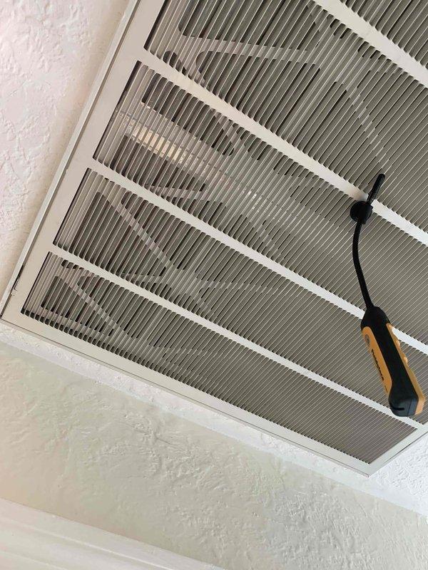 Completed comprehensive cooling season tune-up on single AC unit with ground-level condenser and attic air handler. Condenser coils showed significant accumulation of dirt, dust, and organic debris requiring thorough cleaning to restore proper airflow and heat transfer efficiency. Return air filter grille in attic displayed heavy dust buildup and discoloration, with filter media requiring replacement due to excessive dirt loading that was restricting system airflow and reducing overall performance.