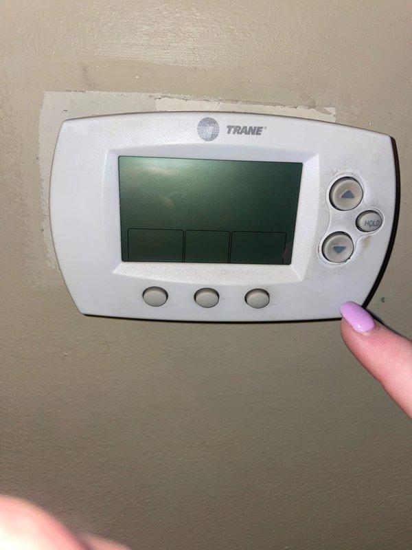 Responded to service call for malfunctioning Trane thermostat in hallway that was shutting off when touched. Inspected wall-mounted thermostat and ductless mini-split indoor unit, diagnosed intermittent power issue caused by loose wiring connection at thermostat base. Secured all wire terminals, tested thermostat functionality and communication with system, verified proper operation and temperature control response.