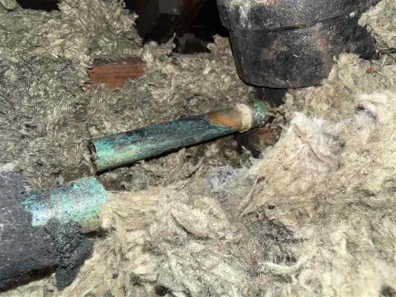 Responded to service call for HVAC drain line repair in attic space. Upon inspection, found severely corroded copper condensate drain line with advanced oxidation and deterioration, exhibiting green verdigris patina throughout affected sections. Removed and disposed of failed drain line components. Installed approximately 30-35 feet of new PVC drain line with proper trap configuration to ensure adequate condensate removal. Utilized four 3/4-inch elbow fittings and two couplings to route new drain line appropriately through attic space and insulation. Verified proper pitch and drainage flow upon completion. System tested and operational.