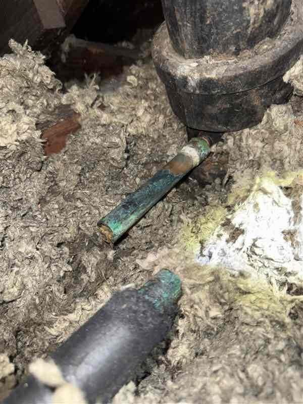 Responded to service call for HVAC drain line repair in attic space. Upon inspection, found severely corroded copper condensate drain line with advanced oxidation and deterioration, exhibiting green verdigris patina throughout affected sections. Removed and disposed of failed drain line components. Installed approximately 30-35 feet of new PVC drain line with proper trap configuration to ensure adequate condensate removal. Utilized four 3/4-inch elbow fittings and two couplings to route new drain line appropriately through attic space and insulation. Verified proper pitch and drainage flow upon completion. System tested and operational.