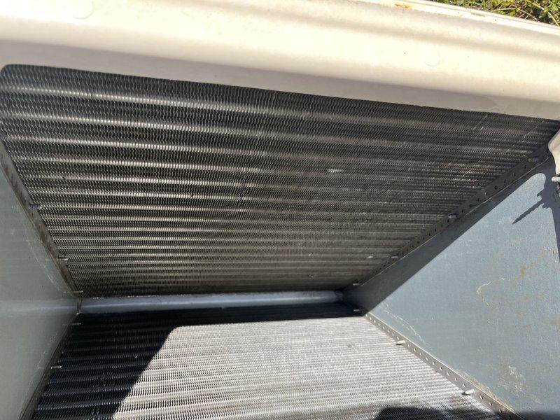 Removed evaporator coil from HVAC unit for thorough external cleaning due to significant dirt and debris accumulation affecting approximately two-thirds of the coil surface. The coil exhibited heavy blackened discoloration and grime buildup that was restricting proper airflow and heat exchange efficiency. After cleaning, reinstalled the evaporator coil and restored unit to proper operating condition.