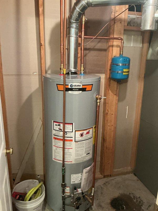 Installed a 50-gallon tall gas water heater in the walkout basement, connecting copper supply lines with shutoff valves and installing a blue expansion tank mounted to the wall framing. Configured the galvanized flue vent system extending from the top of the State brand unit and completed all connections per manufacturer specifications and local code requirements. All components were tested and verified operational upon completion of the installation.
