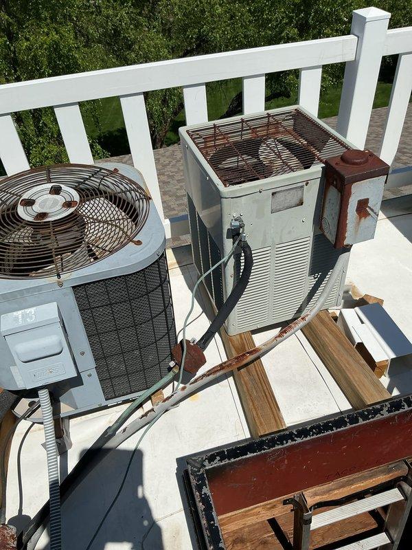 Diagnosed no-cooling condition on rooftop condenser unit and traced electrical fault from outdoor unit back through attic to junction box near hatch. Found damaged low voltage and high voltage wiring inside weatherhead whip with evidence of water intrusion, rust, and corrosion throughout conduit run. Confirmed 24V present at attic junction box but no continuity through damaged conductors to rooftop unit. Recommended complete whip replacement from attic junction box to condenser, including both 24V control wiring and 240V power conductors, as moisture damage compromised entire wire run penetrating through attic roof and main roof structure.