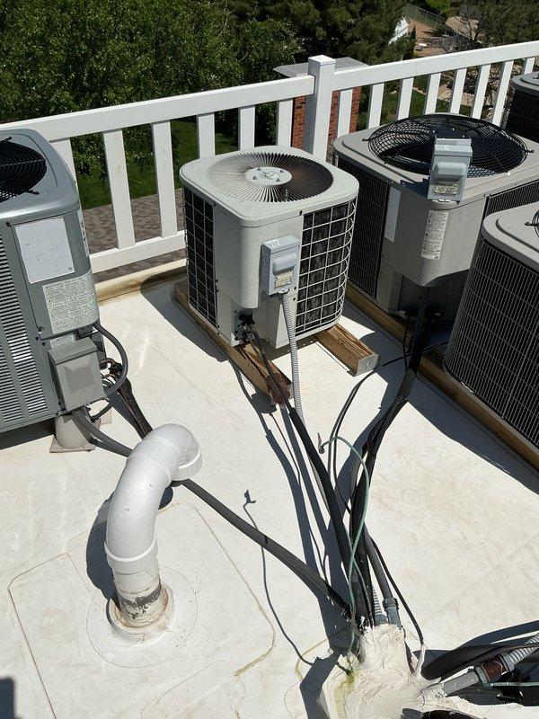 Diagnosed no-cooling condition on rooftop condenser unit and traced electrical fault from outdoor unit back through attic to junction box near hatch. Found damaged low voltage and high voltage wiring inside weatherhead whip with evidence of water intrusion, rust, and corrosion throughout conduit run. Confirmed 24V present at attic junction box but no continuity through damaged conductors to rooftop unit. Recommended complete whip replacement from attic junction box to condenser, including both 24V control wiring and 240V power conductors, as moisture damage compromised entire wire run penetrating through attic roof and main roof structure.