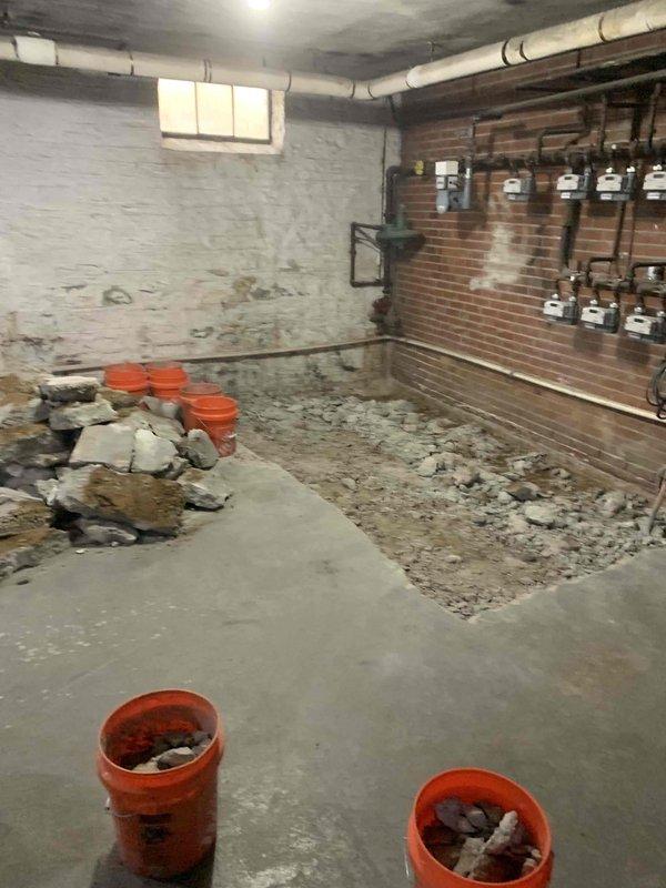 Completed commercial piping installation in basement utility room under plumbing permit PL26-000193 and right of way permit ROW26-000083. Excavated and removed existing concrete flooring to access subsurface for new underground plumbing infrastructure installation. Coordinated work around existing utility meter arrays and building systems mounted on brick wall, ensuring no disruption to active gas and water distribution equipment during excavation and piping installation phases.