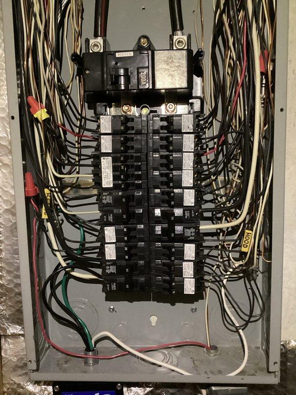 Completed comprehensive electrical panel rejuvenation and surge protector installation on residential service entrance equipment. Inspected and documented existing panel configuration showing main disconnect, dual-column circuit breaker arrangement with approximately 20-30 individual breakers, and multiple branch circuit wiring in standard color coding. Performed necessary upgrades to enhance system protection and reliability per current electrical code requirements.