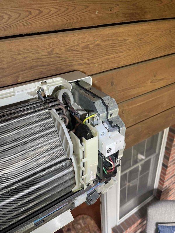 Replaced defective evaporator coil on wall-mounted ductless mini-split air conditioning unit under warranty coverage. Removed front access panel to access internal components, disconnected electrical connections and refrigerant lines, extracted failed evaporator coil assembly (S/N 6009299T), and installed new replacement unit. Reconnected all wiring, secured motor assembly and mounting brackets, verified proper installation of heat exchanger fins, reassembled unit housing, and confirmed system operational status with heat and cool functionality tested successfully.