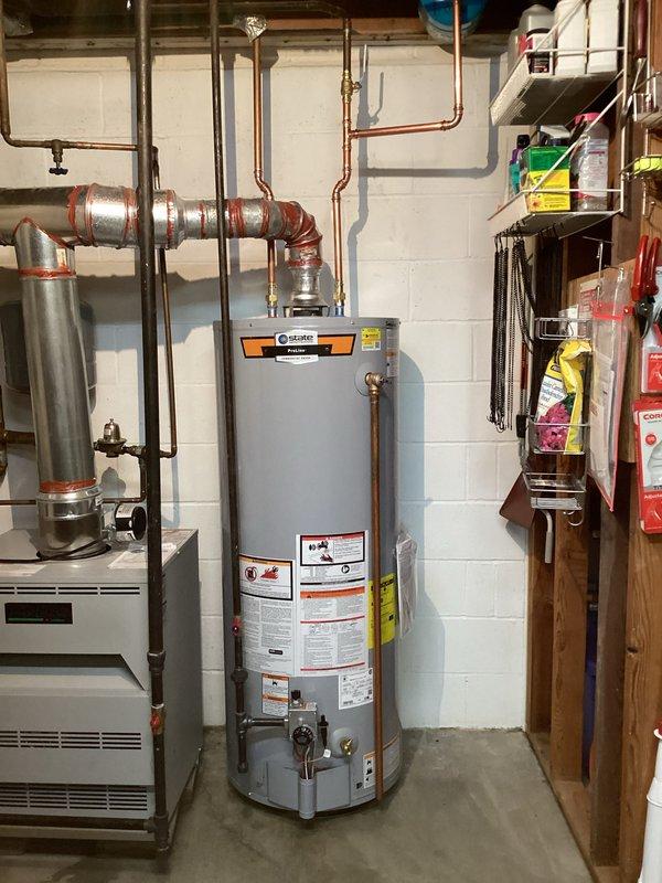 Completed installation of 50-gallon tall gas water heater in basement mechanical room. Connected copper supply piping with shutoff valves, installed proper venting system with metallic duct connections, and integrated expansion tank into the system. Applied required plumbing identification sticker per permit #26PLU-07323 and verified all connections for proper operation and code compliance.