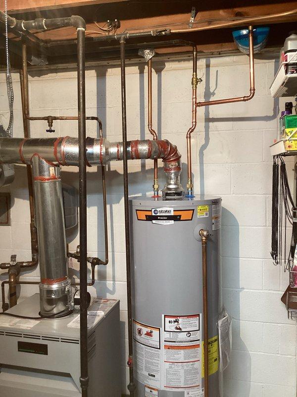 Completed installation of 50-gallon tall gas water heater in basement mechanical room. Connected copper supply piping with shutoff valves, installed proper venting system with metallic duct connections, and integrated expansion tank into the system. Applied required plumbing identification sticker per permit #26PLU-07323 and verified all connections for proper operation and code compliance.