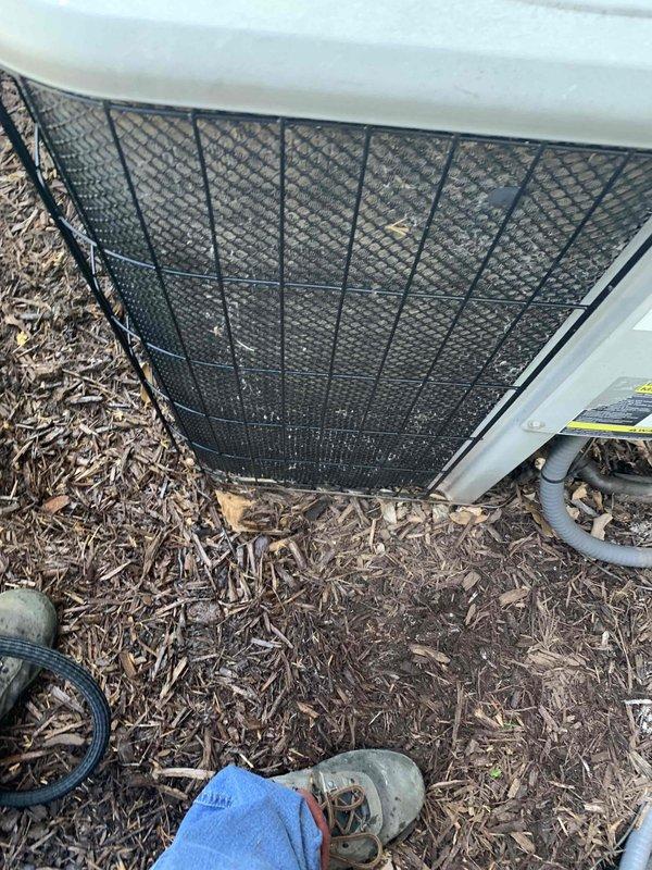 Completed comprehensive spring tune-up on residential air conditioning system. Performed full system inspection including electrical measurements with digital multimeter, verified proper amperage draw and voltage levels at outdoor condensing unit. Unit located on exterior wall with adequate clearance and wood chip mulch base for drainage. All components operating within normal parameters with no deficiencies noted during inspection.