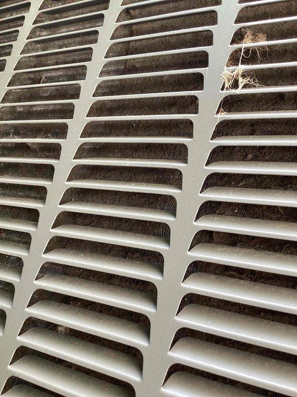 Completed comprehensive tune-up service on two 10-year-old residential air conditioning systems with ground-level exterior condensers. Performed standard maintenance procedures including system inspection, temperature diagnostics showing 57.4°F evaporator coil readings, and assessment of airflow components. Identified and documented heavy dust and debris accumulation on interior ventilation grilles requiring attention for optimal system performance.