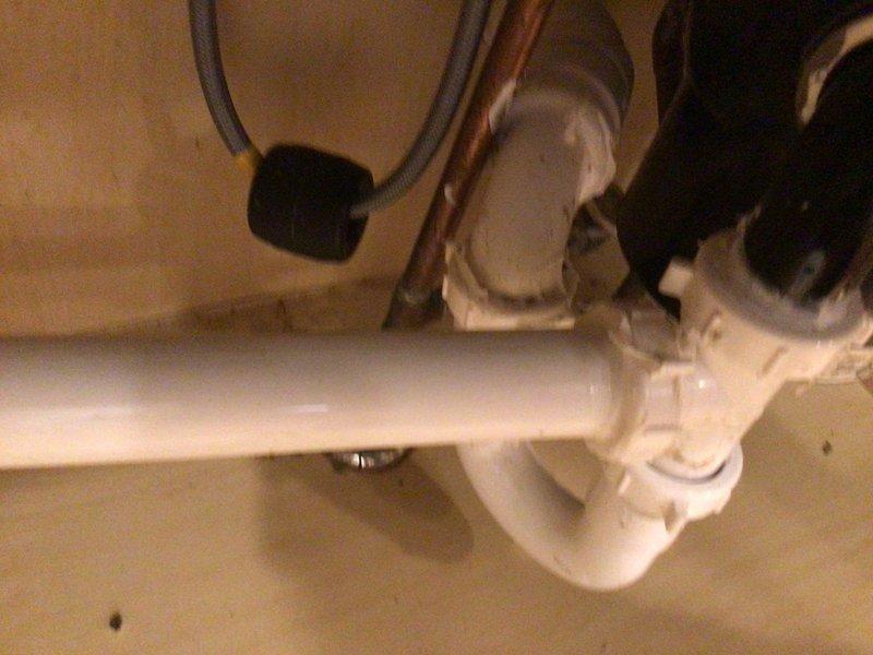 Responded to clogged double kitchen sink drain. Upon inspection, found obstruction in P-trap assembly beneath sink. Disassembled white PVC P-trap configuration and removed accumulated debris causing blockage. Cleaned trap components and verified proper drainage flow through both sink basins. Reassembled P-trap with secure compression fittings and tested system for leaks. Confirmed full drainage restoration and proper operation of double sink drain system.