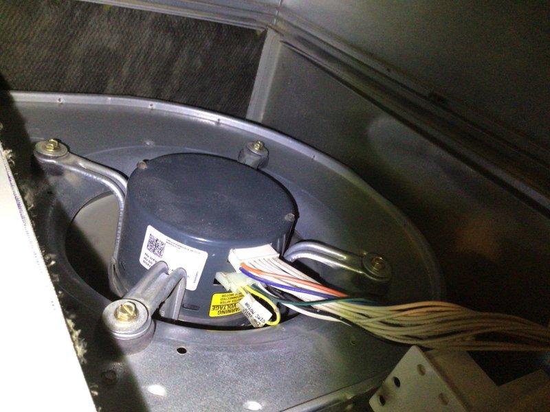 # HVAC Cooling System Tune-Up

Performed comprehensive preventive maintenance service on a 17-year-old residential air conditioning unit located outdoors. Conducted complete system inspection including examination of the blower motor assembly, electrical connections, and capacitor. Evaluated condenser coil condition, noting accumulated debris and dust on fins requiring attention for optimal heat transfer efficiency. Verified all wire connections at motor terminal points, inspected mounting hardware and brackets for secure installation, and assessed overall component condition. Documented system condition through photographic records showing blower assembly with color-coded wiring harnesses and outdoor condenser unit with exposed internal components including dual coil banks, capacitor, and refrigerant lines.