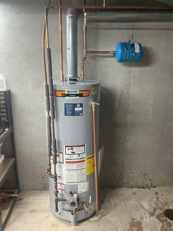 Completed installation of 50-gallon tall gas water heater with proper expansion tank and pressure regulation components. Configured copper supply and distribution piping with brass fittings, shut-off valves, and safety equipment per code requirements. Installation performed under permit #26PLU-07657 with required plumbing identification sticker applied to unit.