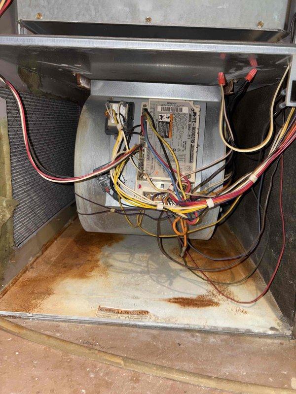 Responded to customer report of excessive noise from air conditioning unit upon seasonal startup. Performed diagnostic inspection of ground-level condenser and basement air handler components. Identified source of loud mechanical noise resembling lawn mower sound. Inspected blower assembly, motor mounts, and internal components for loose hardware, debris, or mechanical failure. Examined electrical connections and control boards within air handler cabinet, noting rust staining on interior base panel indicating previous moisture exposure. Verified proper airflow and cooling operation throughout system. Installed new air filter with clean pleated media. Unit restored to normal operating sound levels while maintaining cooling capacity.