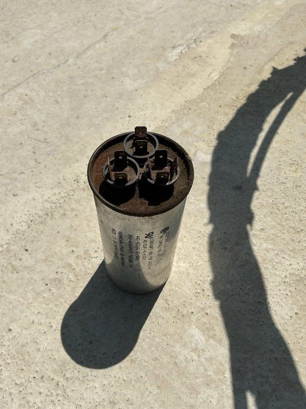Replaced failed capacitor on HVAC unit with new TITAN PRO capacitor from truck stock. Removed old capacitor, installed replacement unit with proper mounting bracket, and reconnected all electrical terminals with appropriate color-coded wiring. System tested and operational upon completion.