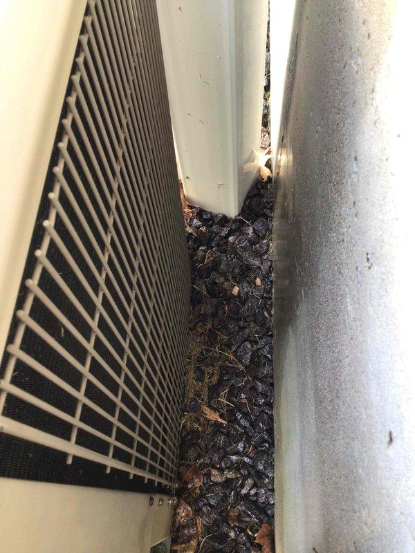 Completed comprehensive cooling tune-up on 21-year-old basement pad unit. Removed significant accumulation of organic debris (leaves, twigs, and decomposed plant material) that had compacted between unit housing and building structure, which was restricting airflow and potentially impacting system efficiency. Performed standard maintenance protocol including inspection of all components, cleaning of exterior surfaces, and verification of proper operation.