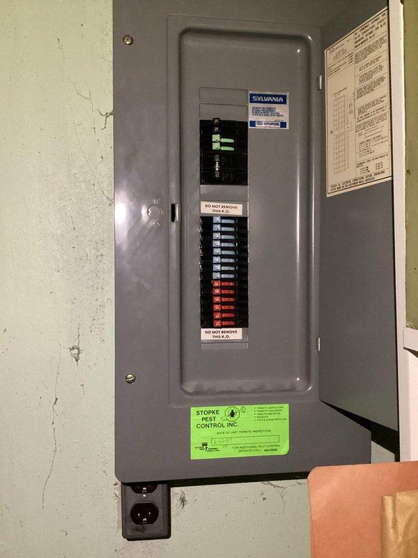 Completed comprehensive electrical safety inspection of residential property. Performed thorough examination of main electrical panel, identifying Sylvania brand main circuit breaker with mixed blue and red individual breakers in serviceable condition. Inspected basement utility area, evaluating exposed copper piping runs, wooden joist ceiling structure, and concrete block foundation walls for potential electrical hazards or moisture concerns that could impact electrical systems.