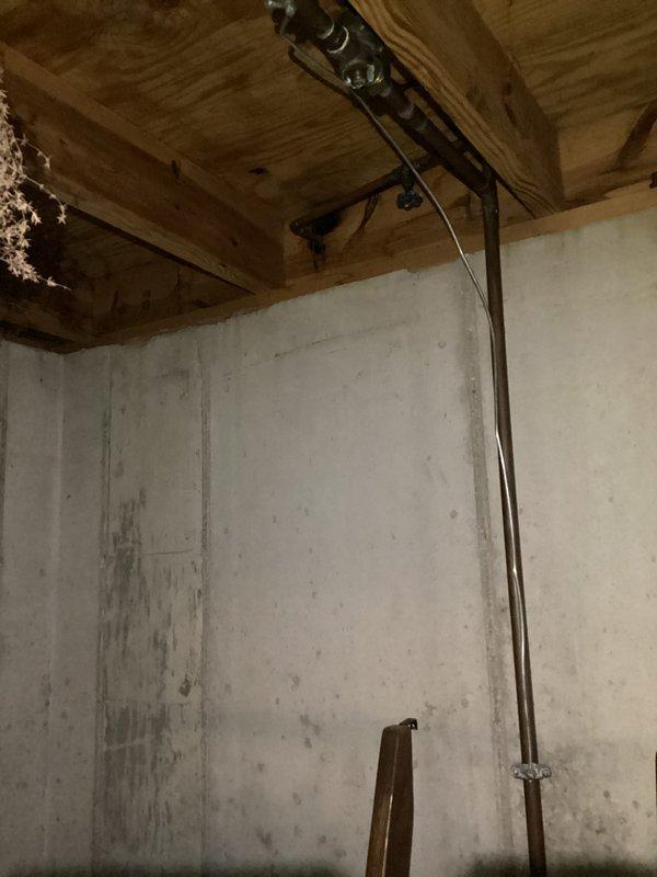 Completed comprehensive electrical safety inspection of residential property. Performed thorough examination of main electrical panel, identifying Sylvania brand main circuit breaker with mixed blue and red individual breakers in serviceable condition. Inspected basement utility area, evaluating exposed copper piping runs, wooden joist ceiling structure, and concrete block foundation walls for potential electrical hazards or moisture concerns that could impact electrical systems.