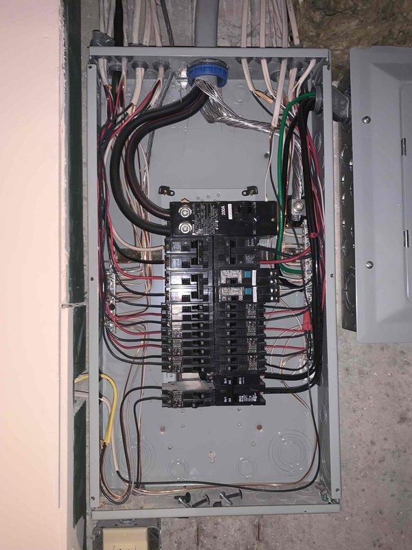 Completed complimentary electrical inspection of residential service panel. Performed comprehensive visual assessment of main electrical panel, documenting circuit breaker configuration, wire management, and overall system integrity. Panel consists of dual bus bar configuration with approximately 12-14 standard residential circuit breakers arranged in two vertical columns. Verified proper color-coded wiring connections including black and red hot conductors to breakers, bundled white neutrals to neutral bus bar, and green ground wires to grounding bus bar. Observed organized wire routing from top entry point with appropriate cable clamps and strain relief. Main disconnect or meter connection point present at top center of panel. All components appear functional with no immediate safety concerns identified during inspection. Photographic documentation captured for record-keeping purposes.
