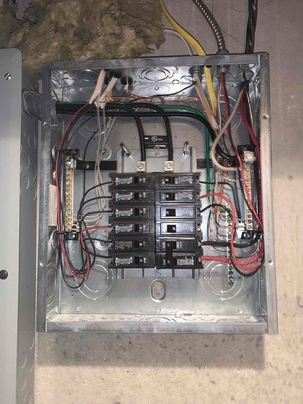 Completed complimentary electrical inspection of residential service panel. Performed comprehensive visual assessment of main electrical panel, documenting circuit breaker configuration, wire management, and overall system integrity. Panel consists of dual bus bar configuration with approximately 12-14 standard residential circuit breakers arranged in two vertical columns. Verified proper color-coded wiring connections including black and red hot conductors to breakers, bundled white neutrals to neutral bus bar, and green ground wires to grounding bus bar. Observed organized wire routing from top entry point with appropriate cable clamps and strain relief. Main disconnect or meter connection point present at top center of panel. All components appear functional with no immediate safety concerns identified during inspection. Photographic documentation captured for record-keeping purposes.