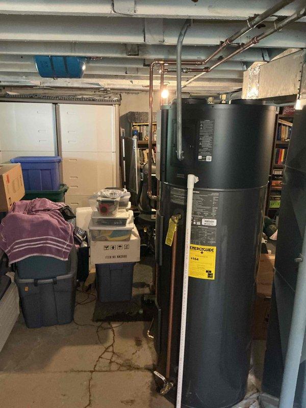 Completed installation of an 80-gallon Navien heat pump water heater (model # NNWP50080) in basement utility room. Unit was delivered and installed with copper supply and discharge piping connections, positioned in central mechanical area with proper clearances for service access. Installation performed under City of Webster Groves permit and did not require plumbing ID sticker per local code requirements.