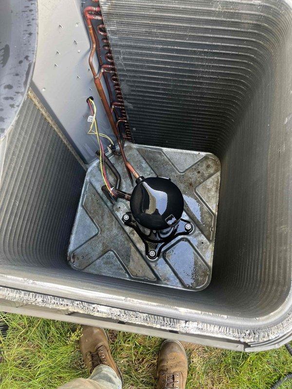 Completed comprehensive cooling season tune-up on 13-year-old outdoor condensing unit. Removed top panel to access internal components, inspected condenser coil condition and copper refrigerant lines for wear and leaks, verified compressor mounting and electrical connections, and performed amperage draw testing using clamp meter to assess system performance. Unit operational with all measurements within acceptable parameters.