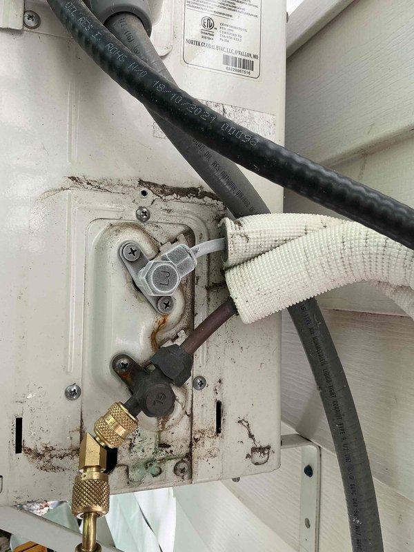 Responded to service call for 6-year-old attic-mounted mini split system reported as turning on but not producing cold air. Performed diagnostic testing using manifold gauges to assess refrigerant pressures and system performance. Inspection revealed corrosion and oxidation at electrical junction box connections and service port fittings. Addressed connection issues at outdoor unit, including corroded terminals and compromised electrical connections. Tested system operation following repairs and verified proper cooling functionality restored to unit.