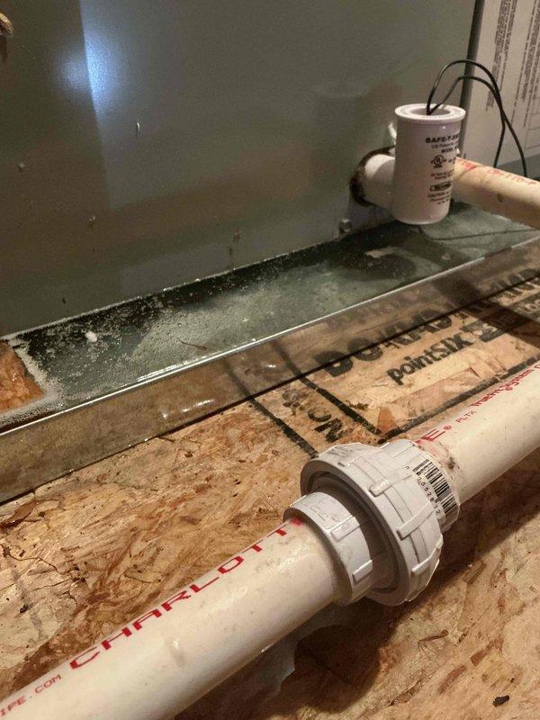 Responded to scheduled service call for HVAC system. Upon arrival, documented existing conditions including condensate drainage system with PVC piping and union fitting, drip pan with standing water accumulation, and evidence of moisture intrusion along foundation perimeter showing black mold growth on subflooring and metal trim junction. Job was cancelled after dispatch and equipment arrival, with photographic documentation completed prior to departure.