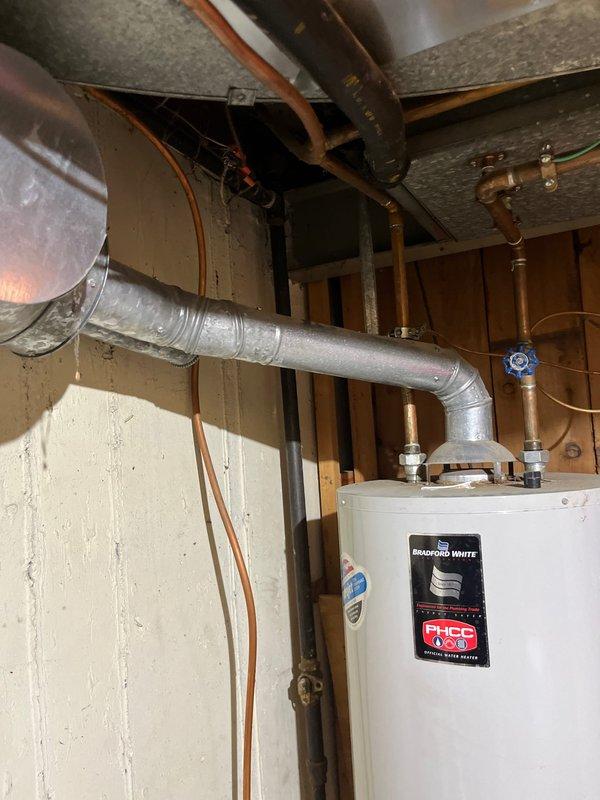 Installed a 50-gallon tall Bradford White gas water heater in the basement utility area. Connected copper supply lines with brass fittings and shutoff valves to the top of the unit, secured all plumbing connections, and verified proper venting configuration. Installation completed per manufacturer specifications in unfinished basement space with all required safety labels and documentation in place.