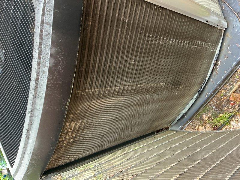Performed seasonal cooling tune-up on 10-year-old single-unit HVAC system. Replaced heavily soiled air filter showing extensive dirt and dust accumulation with severe vertical streaking patterns throughout the media. Inspected outdoor condenser coil and noted significant contamination with dark brown and grayish debris buildup across heat exchanger fins, affecting airflow efficiency. Documented equipment condition with photographic evidence of filter replacement and coil contamination for maintenance records.