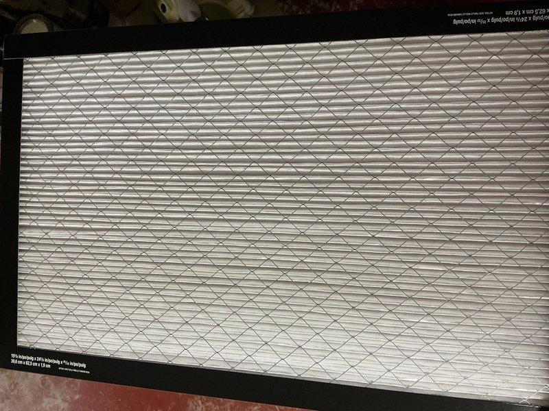 Completed cooling maintenance tune-up on outdoor air conditioning unit. Inspected cylindrical condenser coil with horizontal fins, verified proper operation of fan assembly and protective grille, and examined air filter with diamond-pattern mesh design. System confirmed operational with all components functioning within normal parameters.