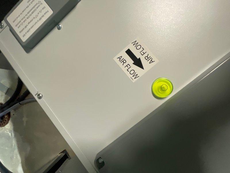 Responded to recall for newly installed dehumidifier experiencing abnormal blowing noise in basement. Inspected unit installation, verified proper airflow direction marking and leveling of equipment. Documented equipment positioning and alignment with photographic evidence showing unit level and airflow indicators functioning as designed.
