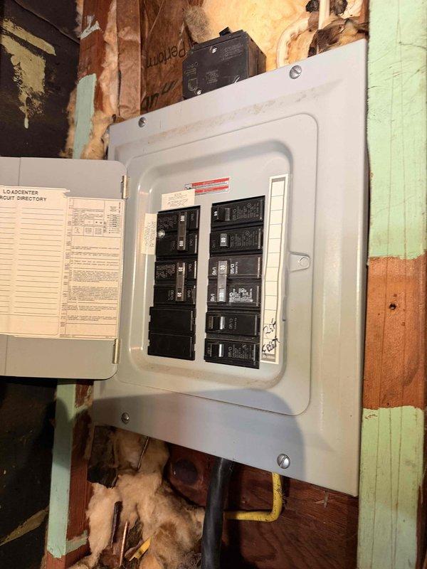 Performed comprehensive inspection of residential electrical panel and breaker box as requested. Upon arrival, accessed interior wall cavity where 100-amp load center is mounted on exposed wooden framing. Conducted visual examination of all circuit breakers, verifying proper seating and connection integrity within the two vertical bus bars. Inspected panel interior for signs of overheating, arcing, or damaged components—all breakers found to be functioning within normal parameters.

Assessed surrounding installation conditions, noting exposed wooden studs with evidence of previous water intrusion and deteriorated wall materials in vicinity of panel. Verified electrical conduits and wire routing below panel box, confirming secure connections and proper support. Examined panel door, load center circuit directory label, and overall enclosure integrity. All electrical components operating safely with no immediate hazards identified requiring emergency repair.